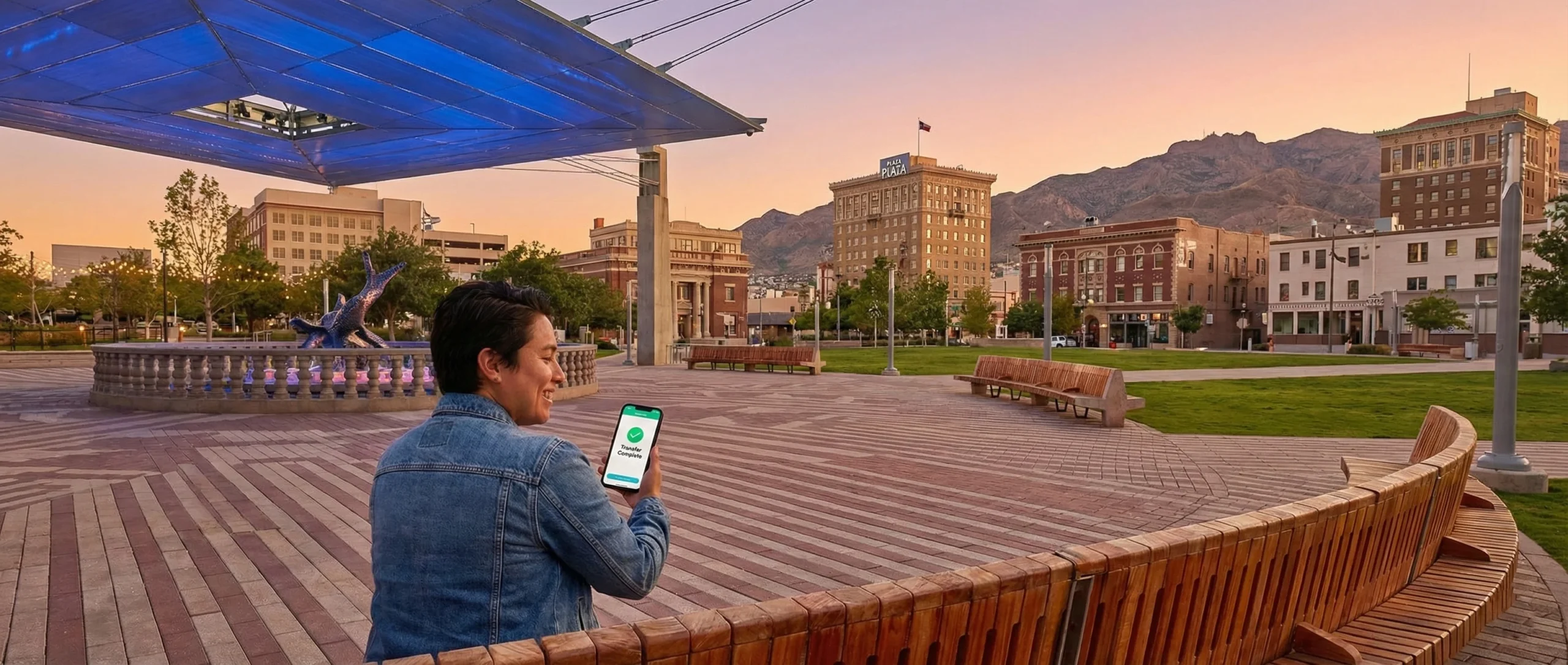 A relieved resident in downtown El Paso, TX, receiving an emergency loan approval notification on their smartphone.